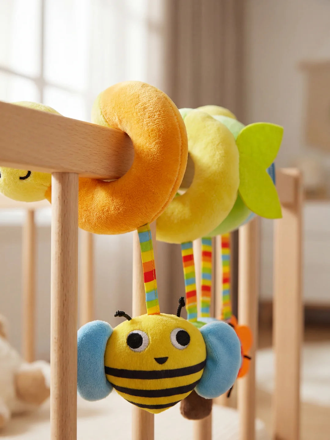 Gros plan sur le hochet abeille jaune et bleu suspendu à la spirale d'activité pour bébé.