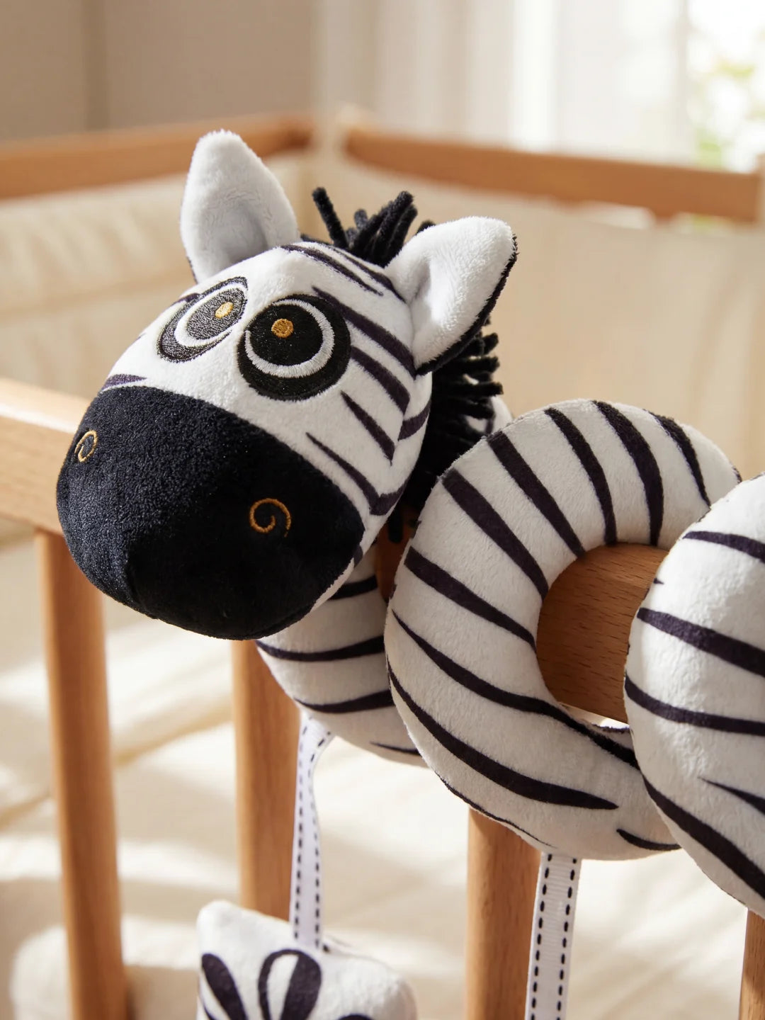 Détail du visage du zèbre en peluche noir et blanc conçu pour l'éveil visuel des nouveau-nés.